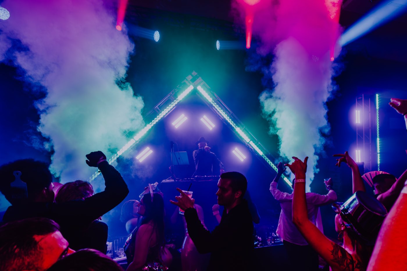 Crowd and stage lights at a live DJ set.